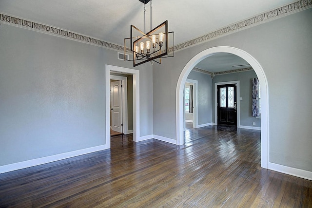 unfurnished room with crown molding, dark hardwood / wood-style flooring, and a chandelier