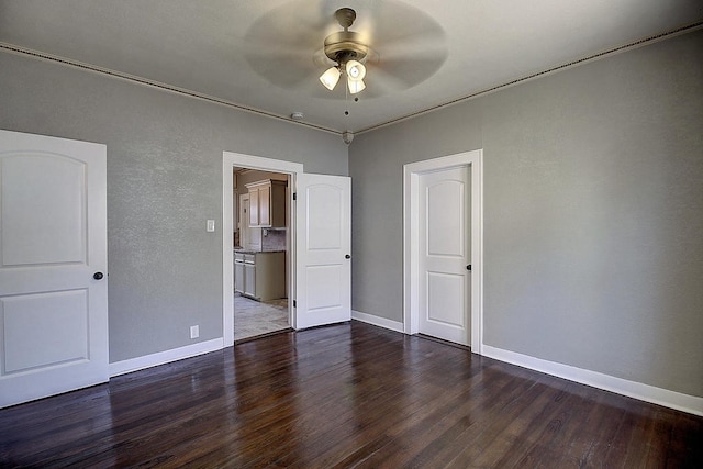 unfurnished bedroom with ceiling fan and dark wood-type flooring