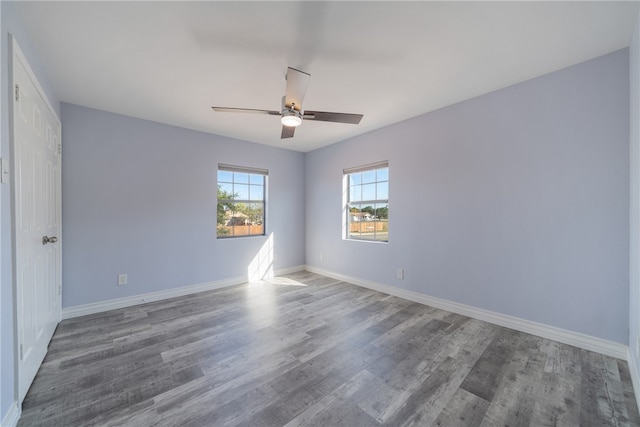 spare room with dark hardwood / wood-style flooring and ceiling fan