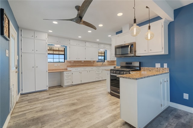 kitchen featuring white cabinets, ceiling fan, stainless steel appliances, and hanging light fixtures