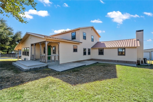 rear view of house featuring a yard and a patio area