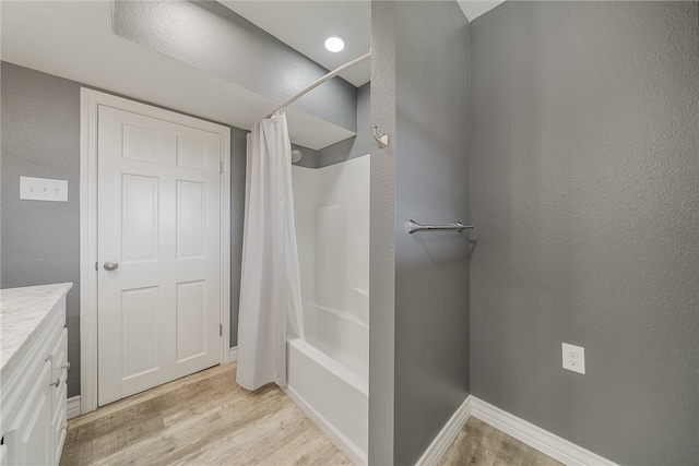 bathroom with shower / bathtub combination with curtain, hardwood / wood-style floors, and vanity