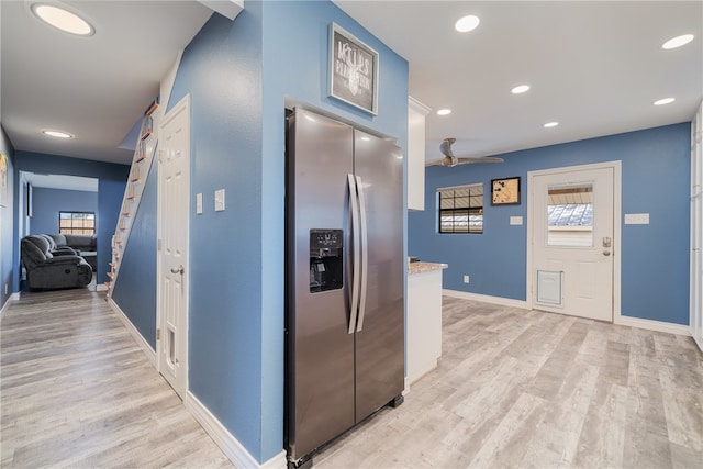 kitchen with ceiling fan, stainless steel fridge, a healthy amount of sunlight, and light hardwood / wood-style flooring