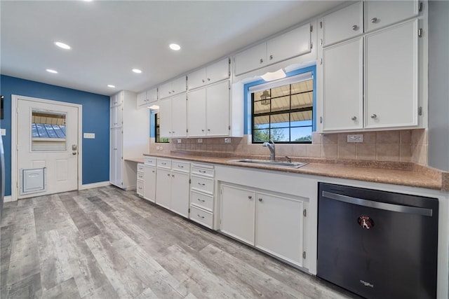 kitchen featuring white cabinets, dishwasher, sink, and tasteful backsplash