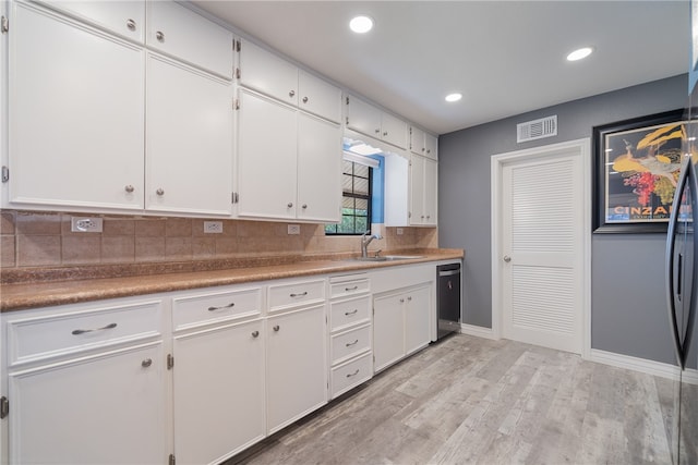 kitchen with decorative backsplash, sink, light hardwood / wood-style flooring, dishwasher, and white cabinets