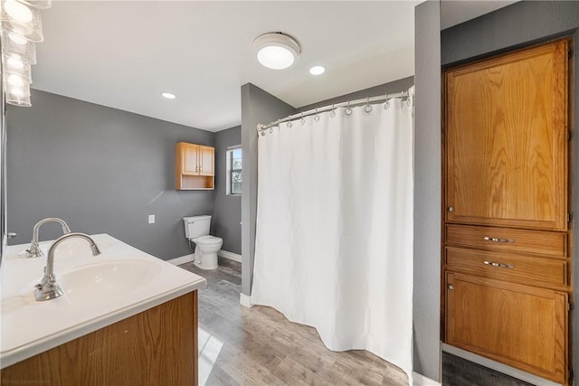 bathroom with hardwood / wood-style floors, vanity, and toilet