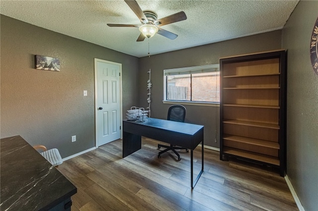 office space with a textured ceiling, ceiling fan, and dark wood-type flooring