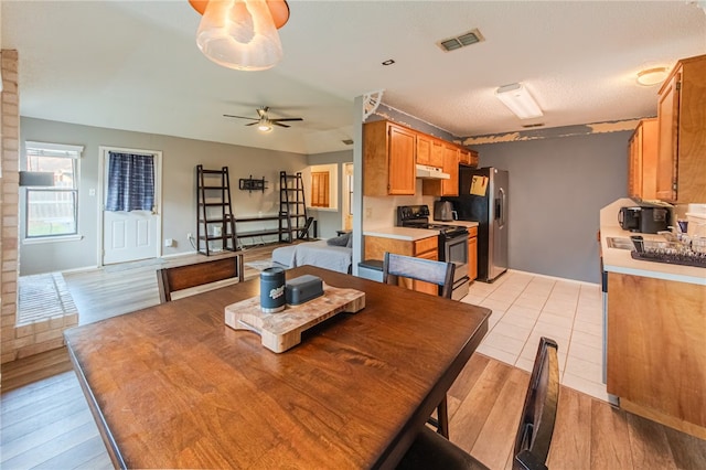 dining area featuring ceiling fan, light hardwood / wood-style floors, and a textured ceiling