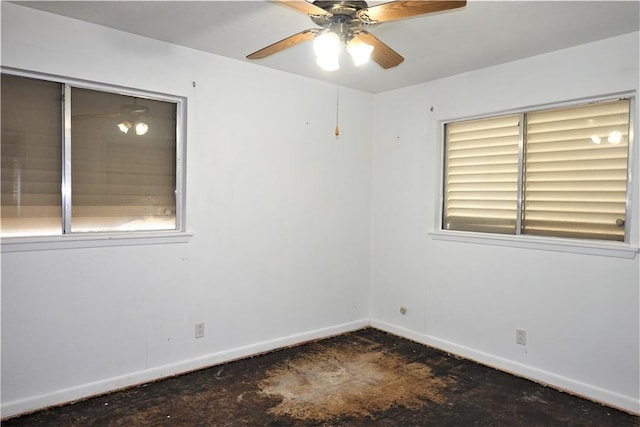 empty room with ceiling fan, baseboards, and unfinished concrete floors