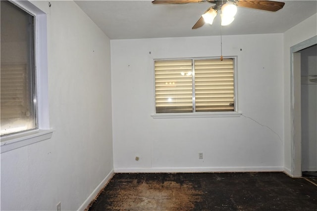 unfurnished room featuring ceiling fan, unfinished concrete flooring, and baseboards