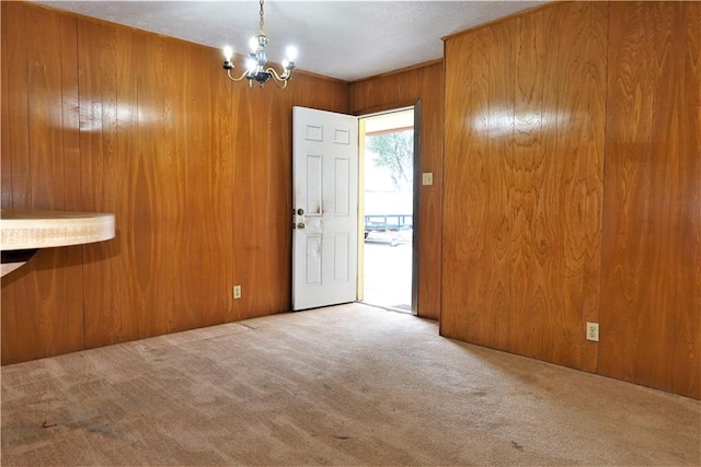 entryway featuring wood walls, carpet, and a notable chandelier