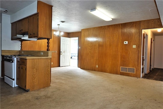 kitchen featuring brown cabinets, white range oven, visible vents, and light countertops