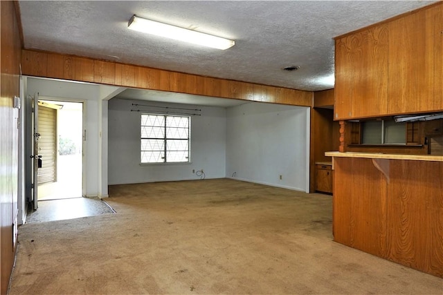 kitchen featuring brown cabinets, light countertops, and a textured ceiling