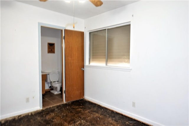 unfurnished bedroom featuring baseboards, a closet, and ensuite bathroom