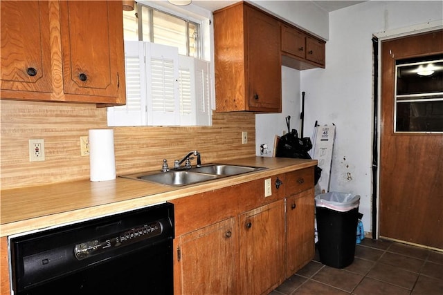 kitchen with black dishwasher, a sink, and brown cabinets