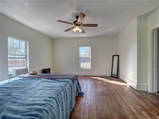 bedroom with ceiling fan, dark hardwood / wood-style flooring, and multiple windows