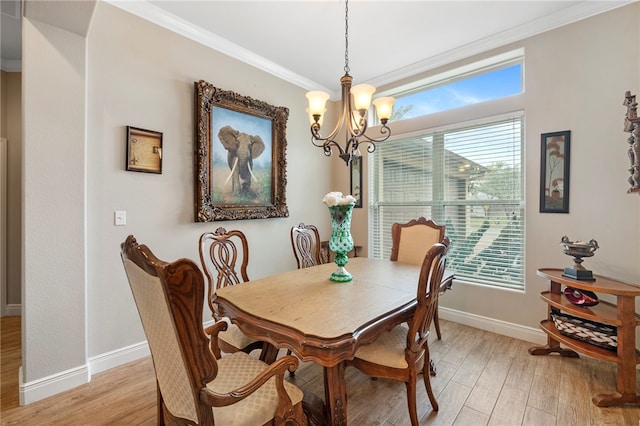 dining area featuring a notable chandelier, ornamental molding, and light hardwood / wood-style flooring