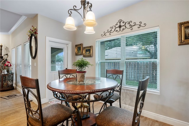 dining room featuring a chandelier, crown molding, and light hardwood / wood-style flooring