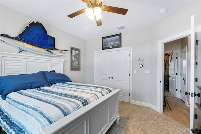 carpeted bedroom featuring ceiling fan and a closet