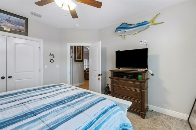 bedroom featuring light colored carpet, ceiling fan, and a closet