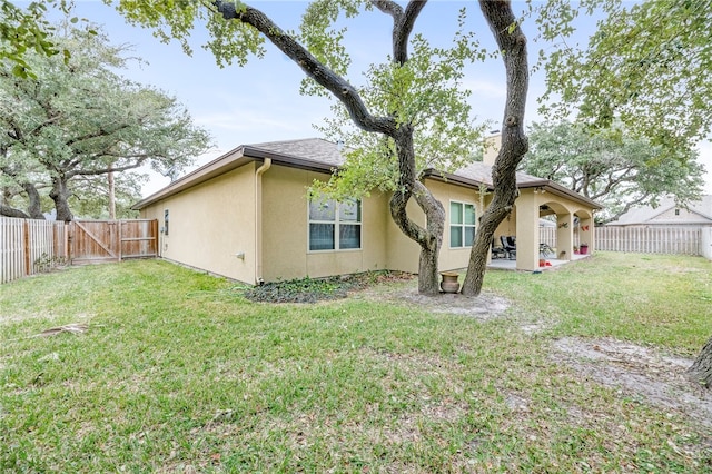 rear view of property featuring a patio and a yard