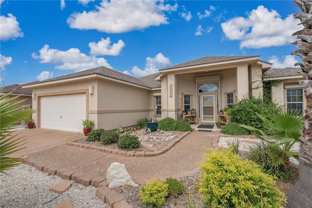 view of front of house featuring a garage, driveway, and stucco siding