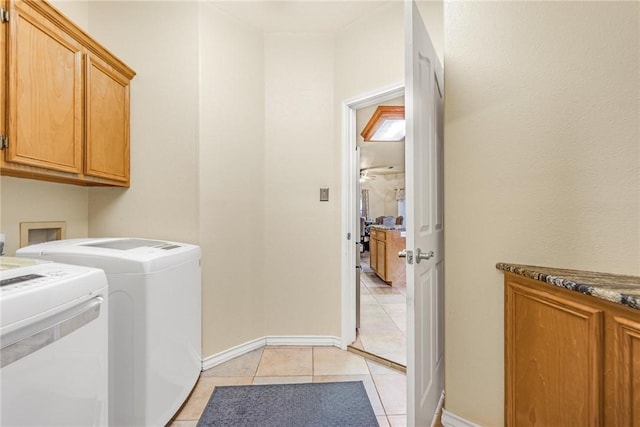 laundry room with cabinet space, light tile patterned floors, baseboards, and washer and clothes dryer