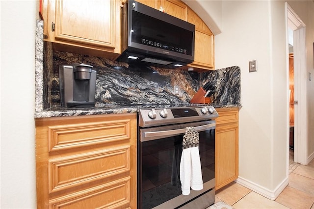 kitchen with stainless steel electric range oven, tasteful backsplash, dark stone countertops, and light tile patterned flooring