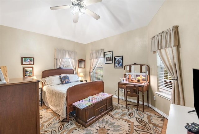 bedroom with light wood finished floors, baseboards, and a ceiling fan