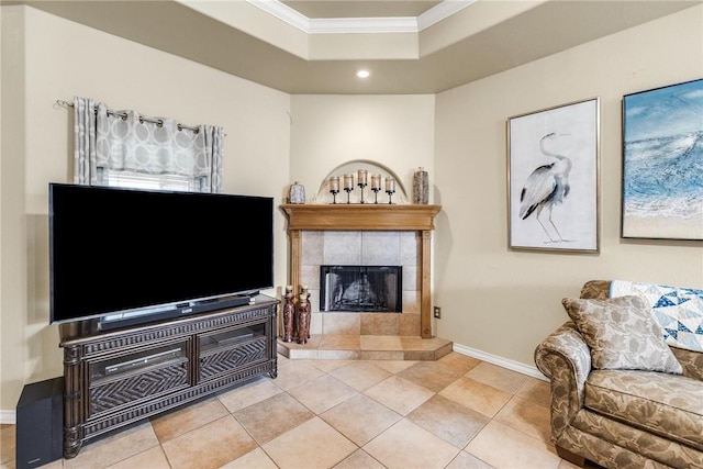 living room with light tile patterned floors, baseboards, a raised ceiling, crown molding, and a fireplace