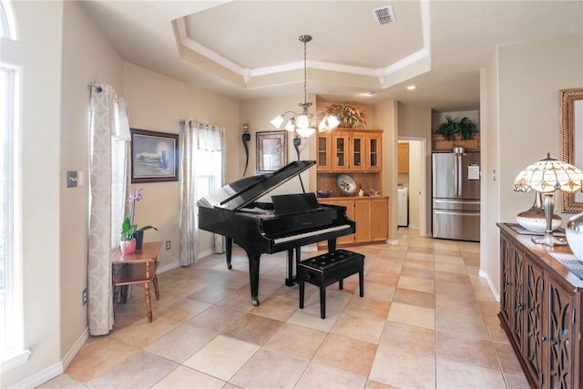 sitting room featuring a chandelier, a raised ceiling, visible vents, and baseboards