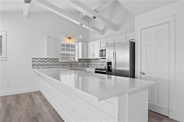 kitchen featuring vaulted ceiling with beams, stainless steel appliances, light countertops, decorative backsplash, and a peninsula