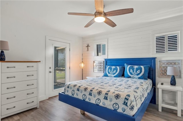 bedroom featuring wood finished floors, a ceiling fan, and access to exterior