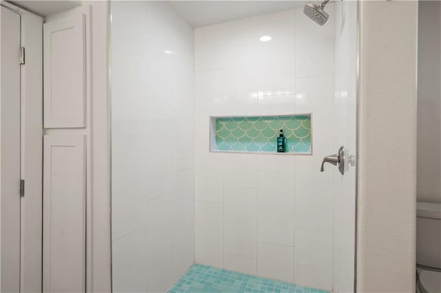 bathroom featuring toilet and tiled shower