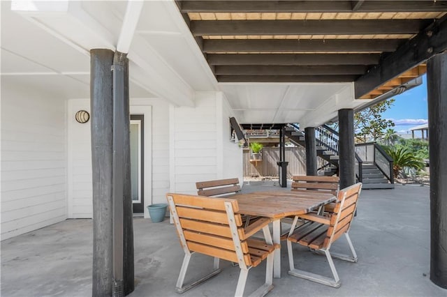 view of patio / terrace featuring outdoor dining space and stairs