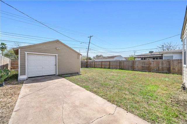 view of yard featuring a garage, driveway, an outdoor structure, and fence