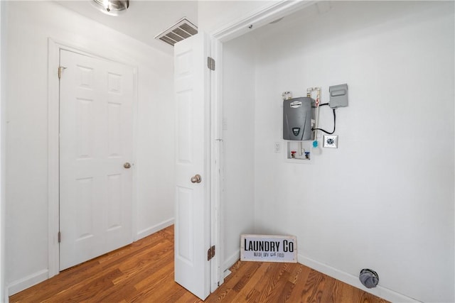 laundry area with hookup for a washing machine, visible vents, wood finished floors, laundry area, and baseboards