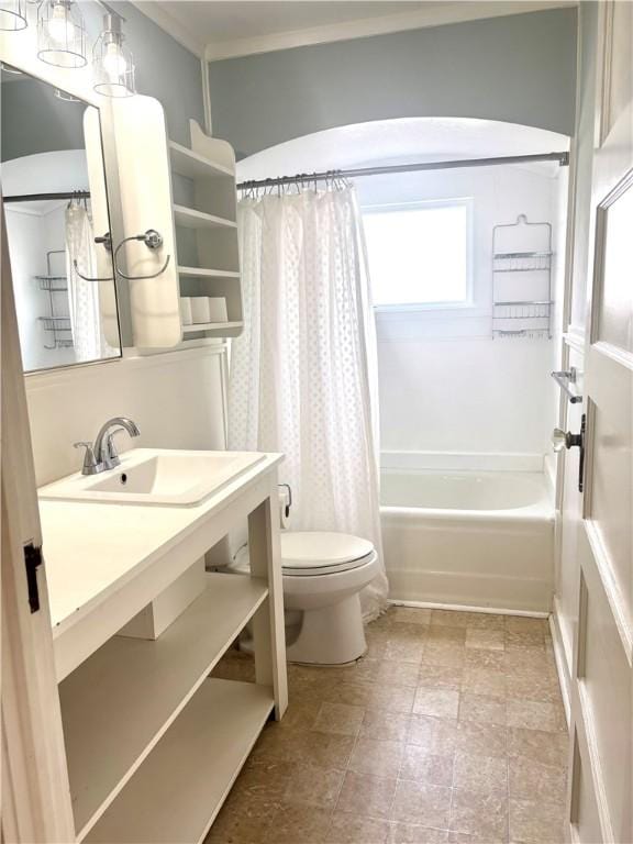 full bath featuring crown molding, vanity, toilet, shower / bath combination with curtain, and stone finish flooring