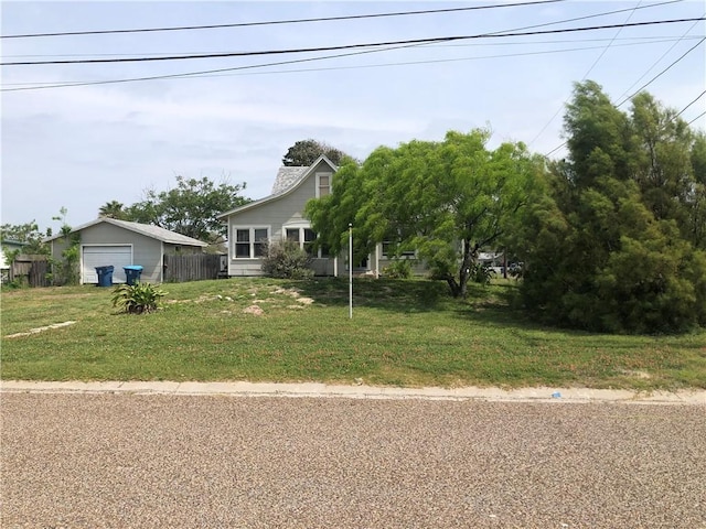 view of front of home with a garage, a front lawn, and fence