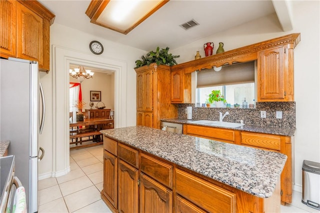 2522 Fleece Dr, Corpus Christi, TX 78414 - kitchen with appliances with stainless steel finishes, a sink, a chandelier, backsplash, and light tile patterned floors