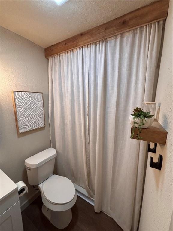 bathroom featuring vanity, walk in shower, a textured ceiling, and toilet