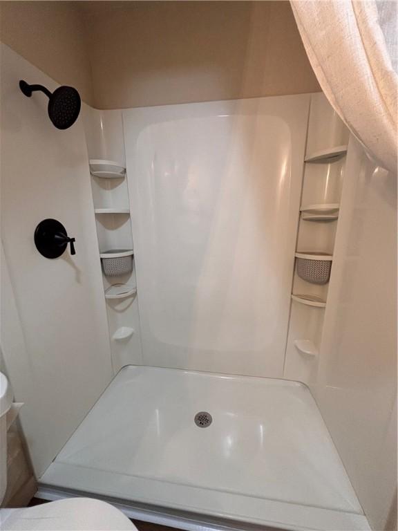 bathroom featuring toilet and walk in shower