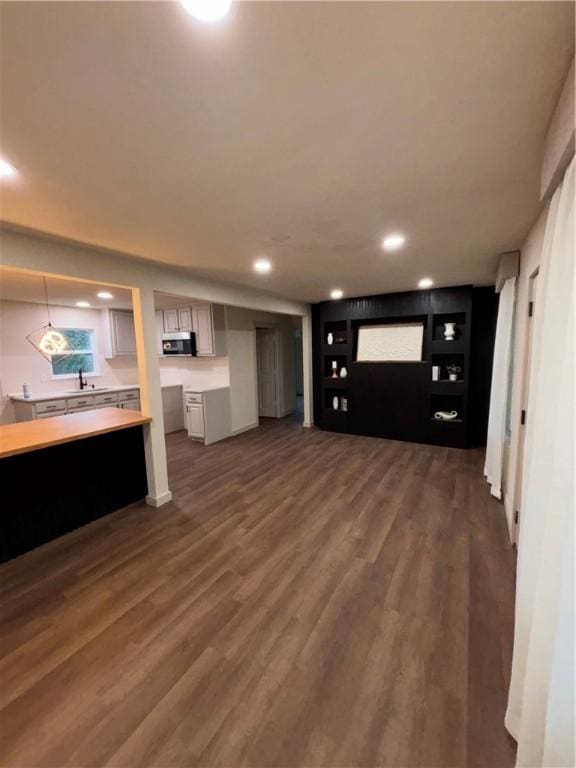 unfurnished living room featuring dark hardwood / wood-style floors and sink