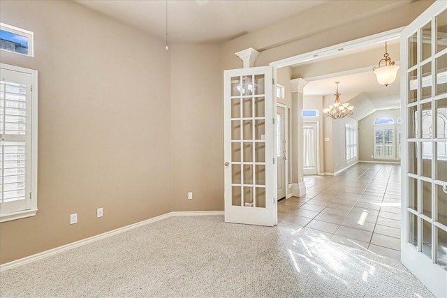 spare room with tile patterned floors, baseboards, an inviting chandelier, and french doors