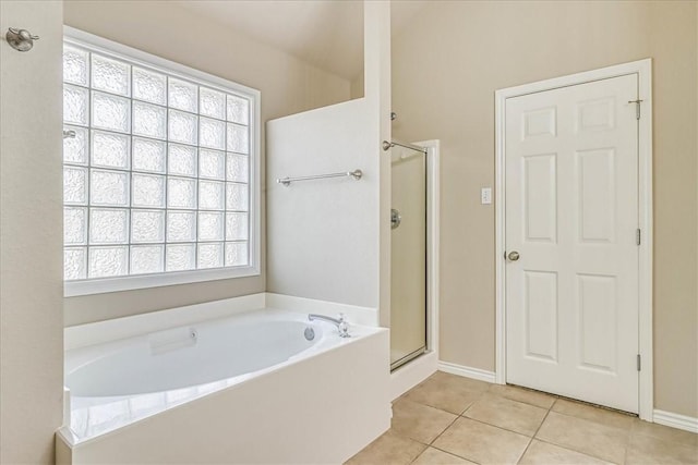 bathroom featuring a stall shower, tile patterned flooring, baseboards, and a bath