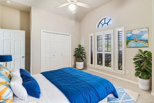 carpeted bedroom with lofted ceiling, ceiling fan, baseboards, and a closet