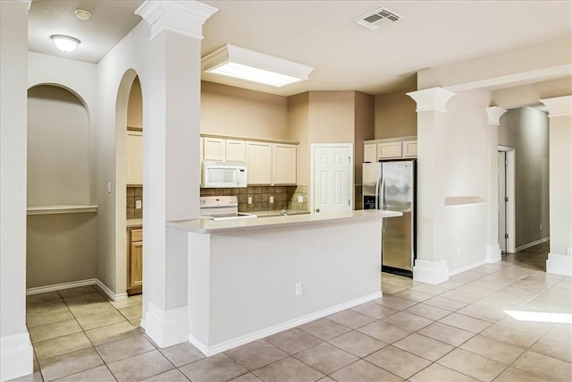 kitchen featuring white microwave, light tile patterned flooring, stove, light countertops, and stainless steel refrigerator with ice dispenser