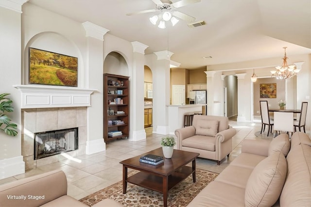 living area featuring light tile patterned floors, a fireplace, a ceiling fan, visible vents, and built in features