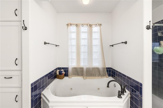 bathroom with a wealth of natural light, a bath, and tile walls