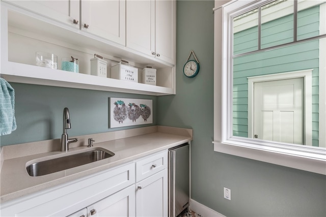 bar featuring white cabinetry, a healthy amount of sunlight, and sink